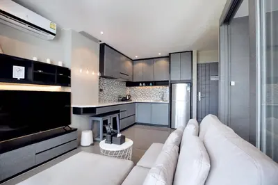 a living room with a white couch and a kitchen at Urban Suite CTG B702 in a Gated Tropics Kamala Residence with 3 Pools & Gym in Kamala Beach