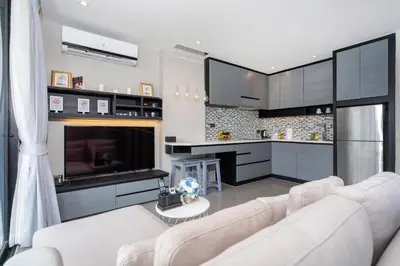 a living room with a white couch and a kitchen at Urban Suite CTG B702 in a Gated Tropics Kamala Residence with 3 Pools & Gym in Kamala Beach