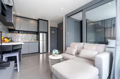 a living room with a white couch and a kitchen at Urban Suite CTG B702 in a Gated Tropics Kamala Residence with 3 Pools & Gym in Kamala Beach