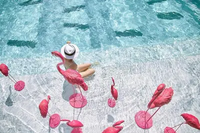 a woman in a pool with pink flamingos in the water at Luxury Suite of 70 Sqm in Rawai Beach in Ban Saiyuan (1)