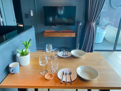 a wooden table with plates and wine glasses on it at Luxury Suite of 70 Sqm in Rawai Beach in Ban Saiyuan (1)