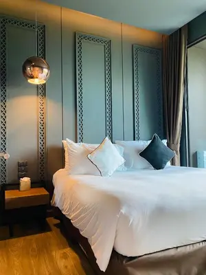 a bedroom with a large white bed with blue walls at Luxury Suite of 70 Sqm in Rawai Beach in Ban Saiyuan (1)