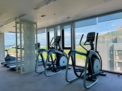 a row of treadmills in a gym with windows at 1BR Apartment with Rooftop Pool - The Base Height Phuket town in Ban Sam Kong