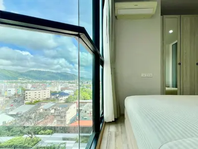 a bedroom with a view of a city at 1BR Apartment with Rooftop Pool - The Base Height Phuket town in Ban Sam Kong