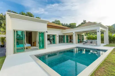 a villa with a swimming pool in front of a house at Brand New Completed v124 in Chalong