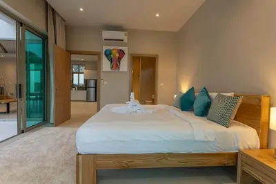 a bedroom with a large white bed with blue pillows at Brand New Completed v124 in Chalong