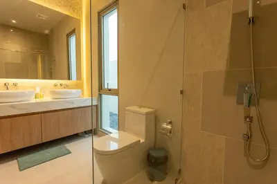 a bathroom with a toilet and two sinks and a shower at Brand New Completed v124 in Chalong