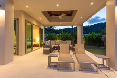 a living room with a table and chairs on a patio at Brand New Completed v124 in Chalong