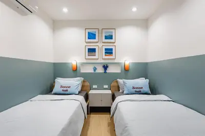two beds in a room with blue and white walls at Patong Apartments Steps to Beach & Bangla Road Sleeps 6 in Patong Beach