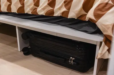 a black suitcase sitting on a bench under a bed at Patong Apartments Steps to Beach & Bangla Road Sleeps 6 in Patong Beach
