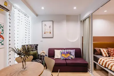 a living room with a purple couch and a table at Patong Apartments Steps to Beach & Bangla Road Sleeps 6 in Patong Beach