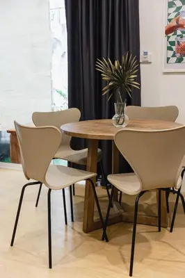 a table and four chairs with a table and a plant at Patong Apartments Steps to Beach & Bangla Road Sleeps 6 in Patong Beach