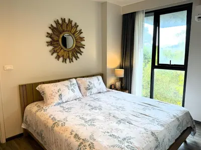a bedroom with a bed and a mirror on the wall at Deck Condo private apartment by Lofty in Patong Beach
