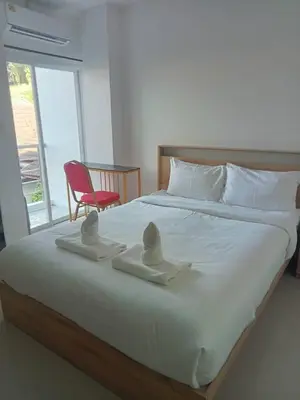 a bedroom with a bed with two hats and a red chair at 07 Antalya Boutique Hotel in Patong Beach