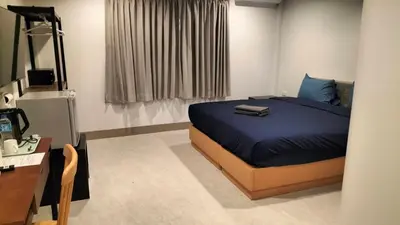 a bedroom with a bed with blue sheets and a desk at JB House Patong in Patong Beach