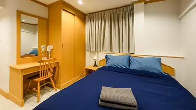 a bedroom with a blue bed and a desk at JB House Patong in Patong Beach