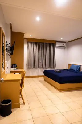 a bedroom with a bed and a desk and a window at JB House Patong in Patong Beach