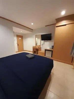 a bedroom with a large blue bed and a television at JB House Patong in Patong Beach