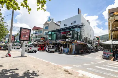 a busy city street with buildings and cars on the road at JB House Patong in Patong Beach
