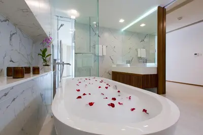 a bathroom with a tub with red flowers on it at The Heights Penthouse A5 3Bedrooms Seaview near Kata Beach in Kata Beach