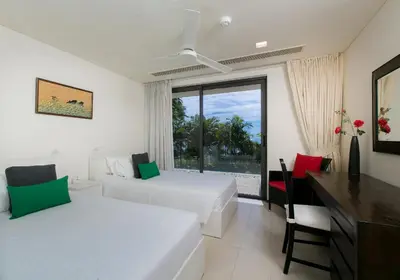 a bedroom with two beds and a desk and a window at The Heights Penthouse A5 3Bedrooms Seaview near Kata Beach in Kata Beach