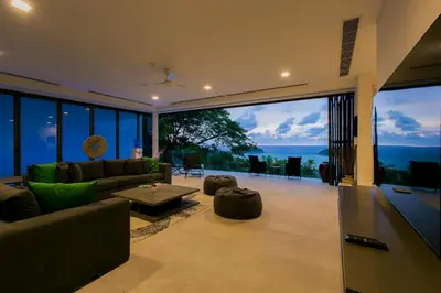 a living room with a couch and a large window at The Heights Penthouse A5 3Bedrooms Seaview near Kata Beach in Kata Beach