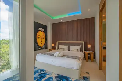 a bedroom with a bed with a painting on the wall at Luxury Pool Villa in Nai Harn - Villa Solana in Rawai Beach