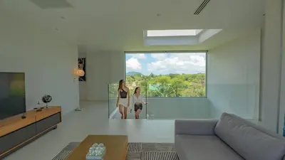 two women standing in a living room looking out the window at Luxury Pool Villa in Nai Harn - Villa Solana in Rawai Beach