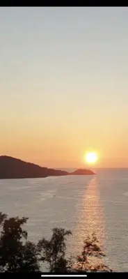 a sunset over a large body of water at Patong Tower Dream Sea View Apartment in Patong Beach