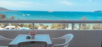 a table and chairs on a balcony with a view of the ocean at Patong Tower Dream Sea View Apartment in Patong Beach