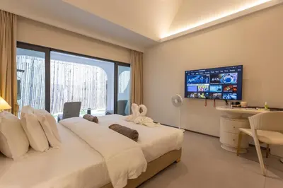 a bedroom with a large bed with a tv on the wall at YUSU Hotel \u7fbd\u5bbf\u9152\u5e97 in Phuket Town