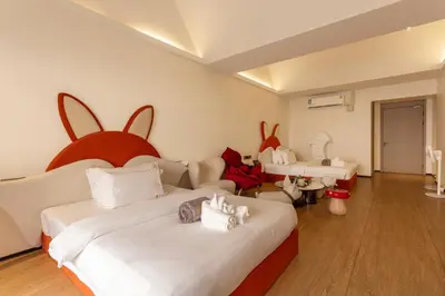 a bedroom with two beds with bunny heads on the wall at YUSU Hotel \u7fbd\u5bbf\u9152\u5e97 in Phuket Town