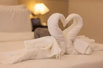 two swans made out of towels on a bed at YUSU Hotel \u7fbd\u5bbf\u9152\u5e97 in Phuket Town