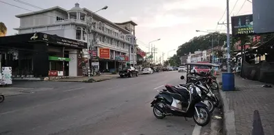 a motorcycle parked on the side of a city street at By the Sea Apartment Hotel in Krabi town