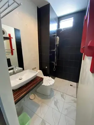 a bathroom with a tub and a toilet and a sink at By the Sea Apartment Hotel in Krabi town