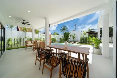 a dining room with a table and chairs at Brand New 4BR Balinese Style Pool Villa Kaia just 5 min drive from NaiHarn Beach in Rawai Beach