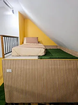 a bed sitting on a wooden platform in a room at Baibon2 Homestay Thalang Phuket in Thalang