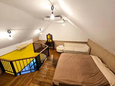 a attic room with a bed and a couch at Baibon2 Homestay Thalang Phuket in Thalang