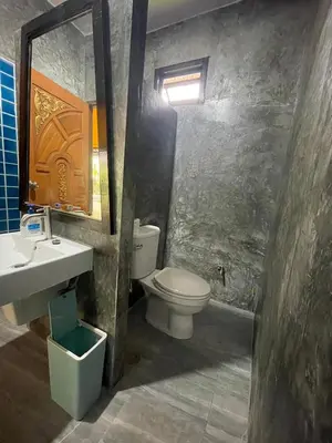 a bathroom with a toilet and a sink and a mirror at Baibon2 Homestay Thalang Phuket in Thalang