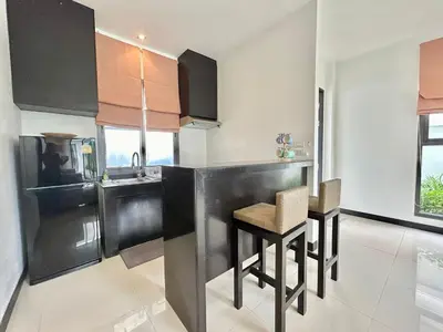 a kitchen with a black counter and a table at Garden 2 bedrooms pool villa in Laguna Phuket