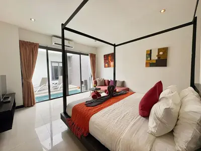 a bedroom with a large bed with red pillows at Garden 2 bedrooms pool villa in Laguna Phuket