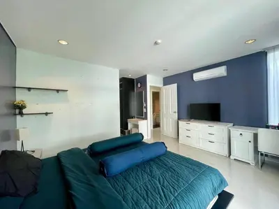 a bedroom with a blue bed and a television at Kamala Regent Condo in Kamala Beach
