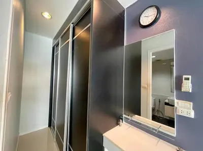a bathroom with a mirror and a clock on a wall at Kamala Regent Condo in Kamala Beach