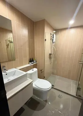 a bathroom with a toilet and a sink and a shower at Centrio room in Ban Rangeng
