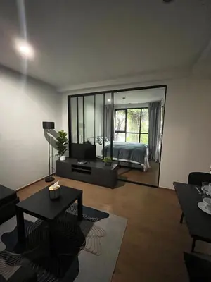 a living room with a bed and a large mirror at Centrio room in Ban Rangeng