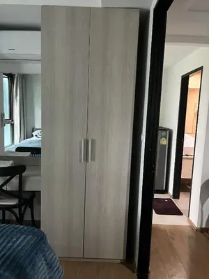 a wooden cabinet in a bedroom next to a bed at Centrio room in Ban Rangeng