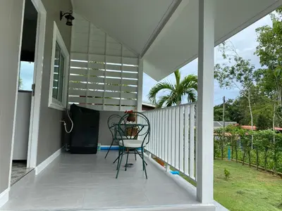 a screened porch with a chair on it at Green Tree Cottage5 in Klong Muang Beach