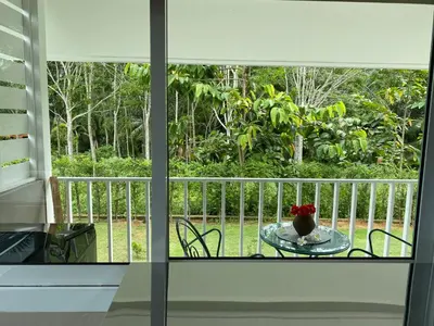 a window with a table and a vase of flowers on a table at Green Tree Cottage5 in Klong Muang Beach