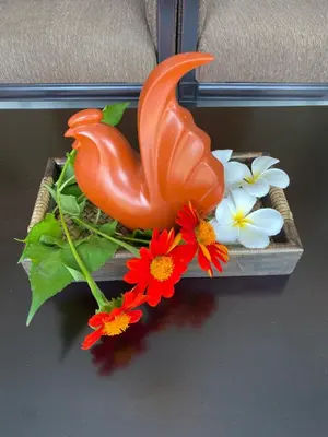 a statue of a bird and flowers on a table at Green Tree Cottage5 in Klong Muang Beach