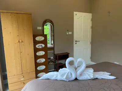 two swans made out of towels sitting on a bed at Green Tree Cottage5 in Klong Muang Beach